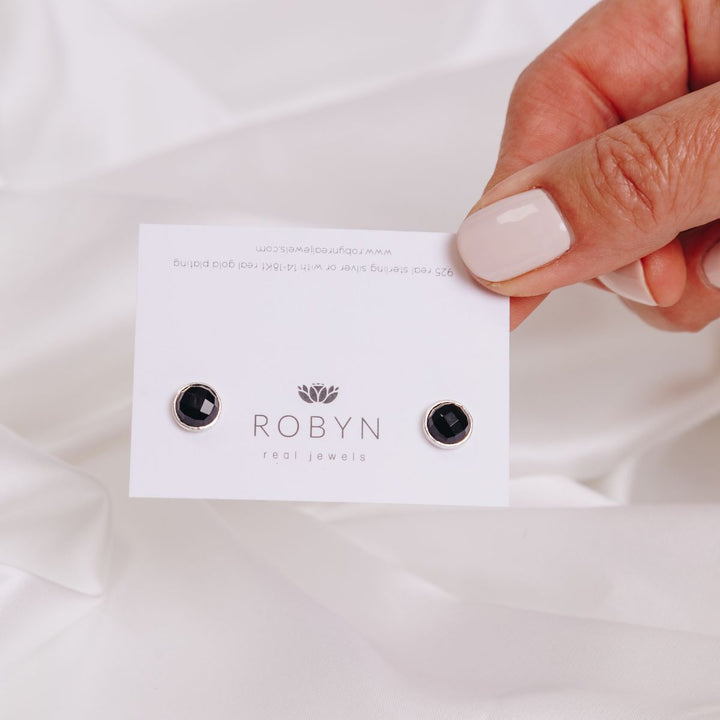 a woman holding  card with earring on