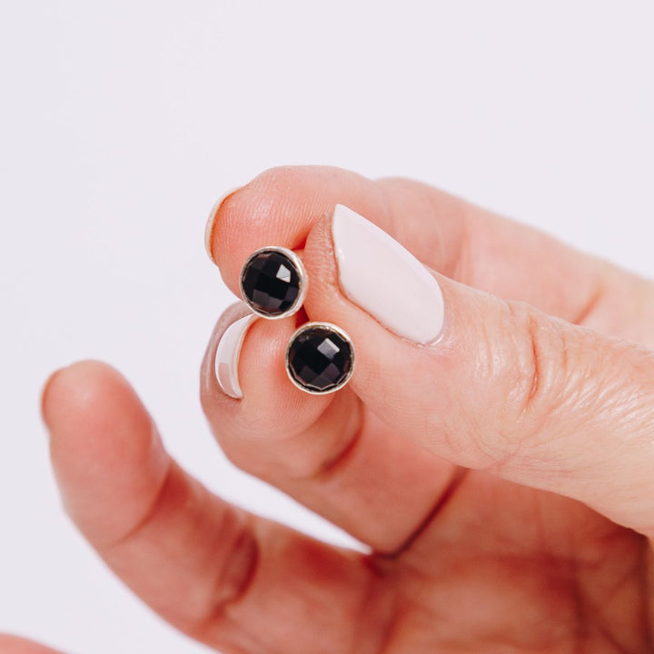 a woman holding earrings in her hand