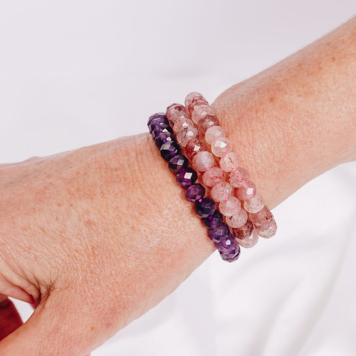 a woman wearing three facetted bracelets on her wrist