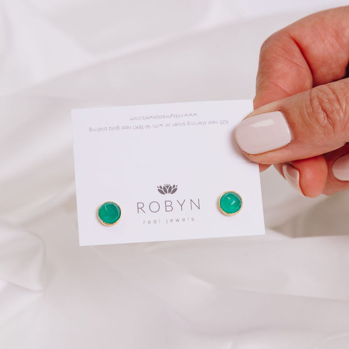 a woman holding a card with earrings in her hand