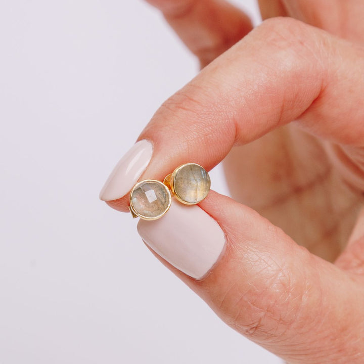 a woman holding earrings in her hand