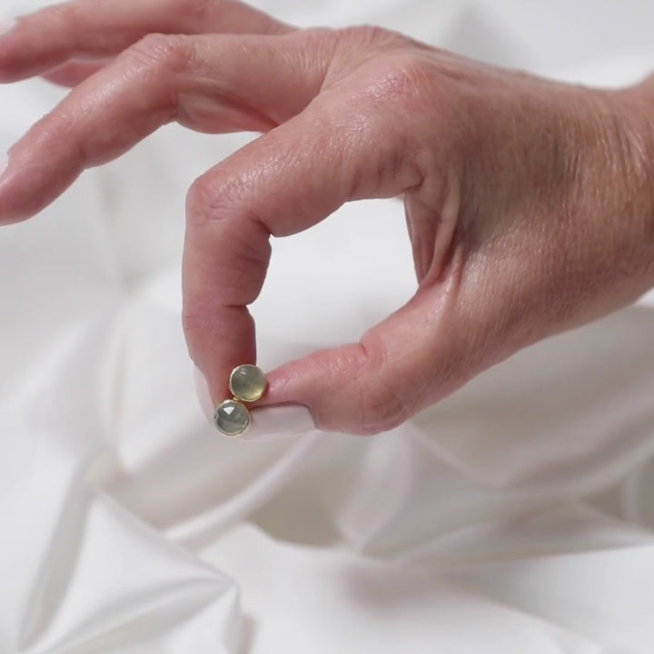a woman holding earrings between her fingers