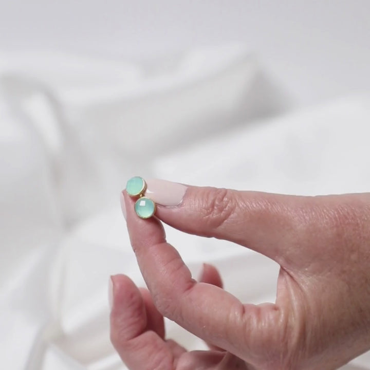 a woman holding earring between her fingers