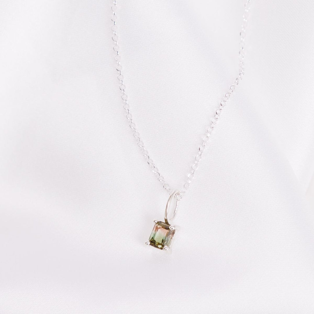 a pendant necklace on a white cloth