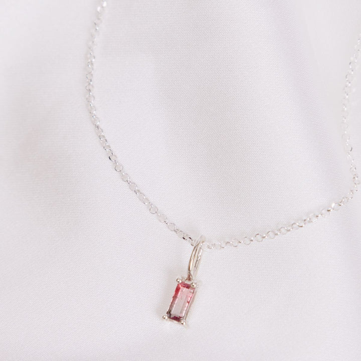 a pendant necklace on a white sheet