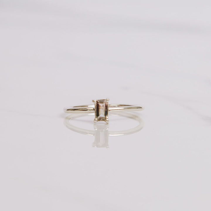 a gemstone ring on a white background