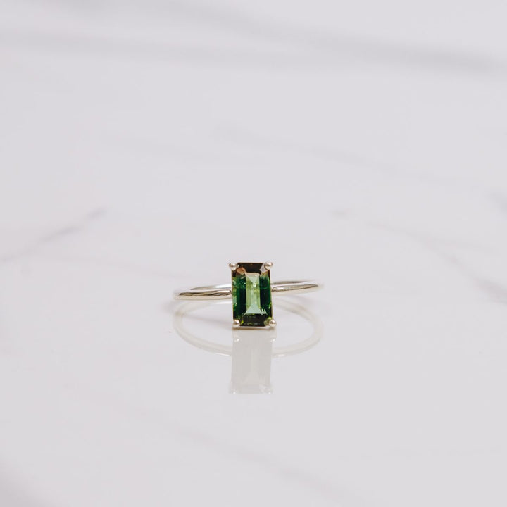 a gemstone ring on a white background