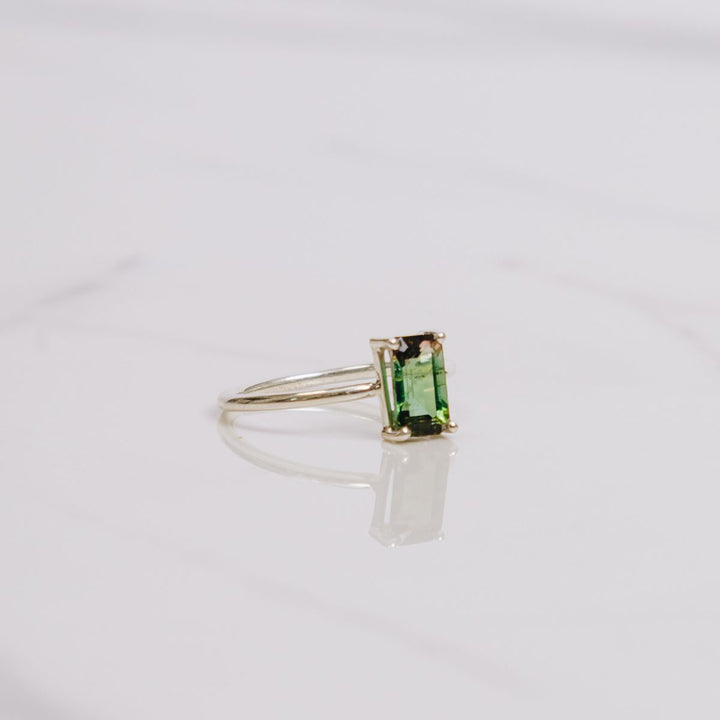 a gemstone ring on a white background