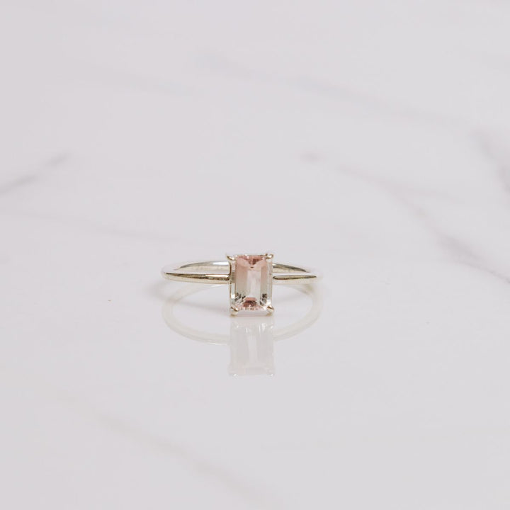 a gemstone ring on a white background