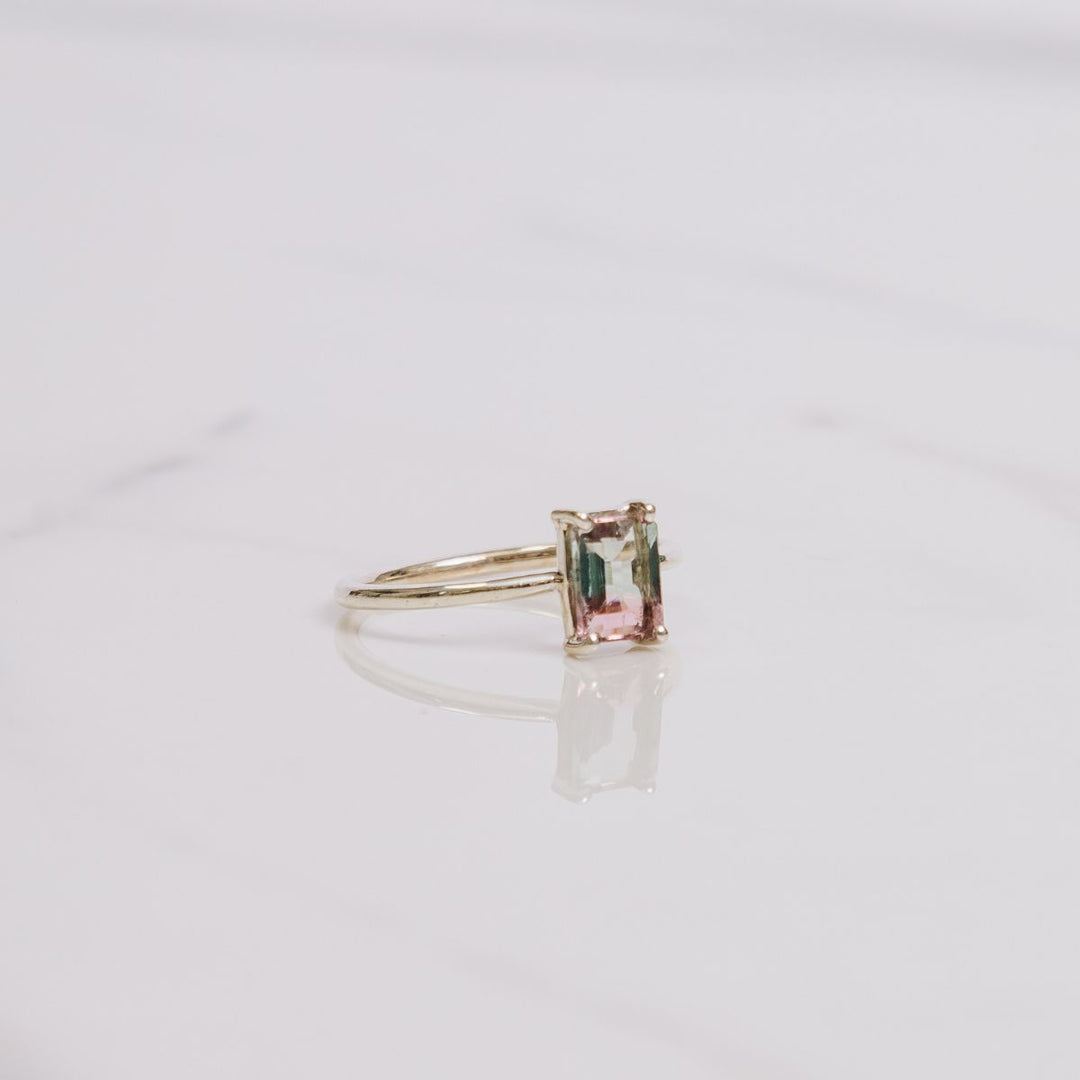 a gemstone ring on a white background