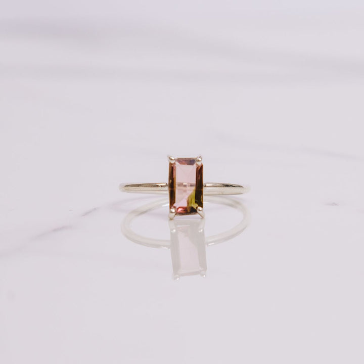 a gemstone ring on a white background