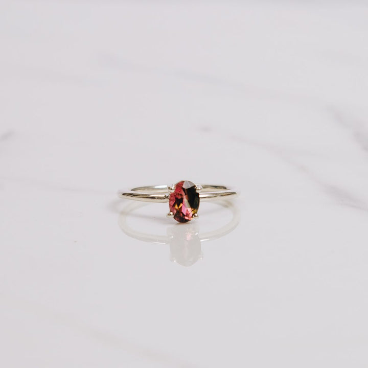 an oval shaped gemstone ring on a white background