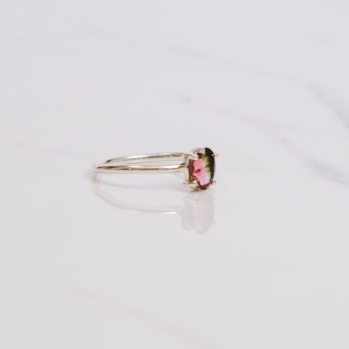 an oval shaped gemstone ring on a white background