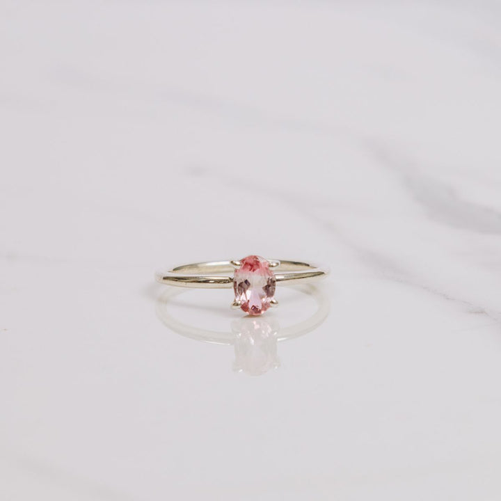 an oval shaped gemstone ring on a white background