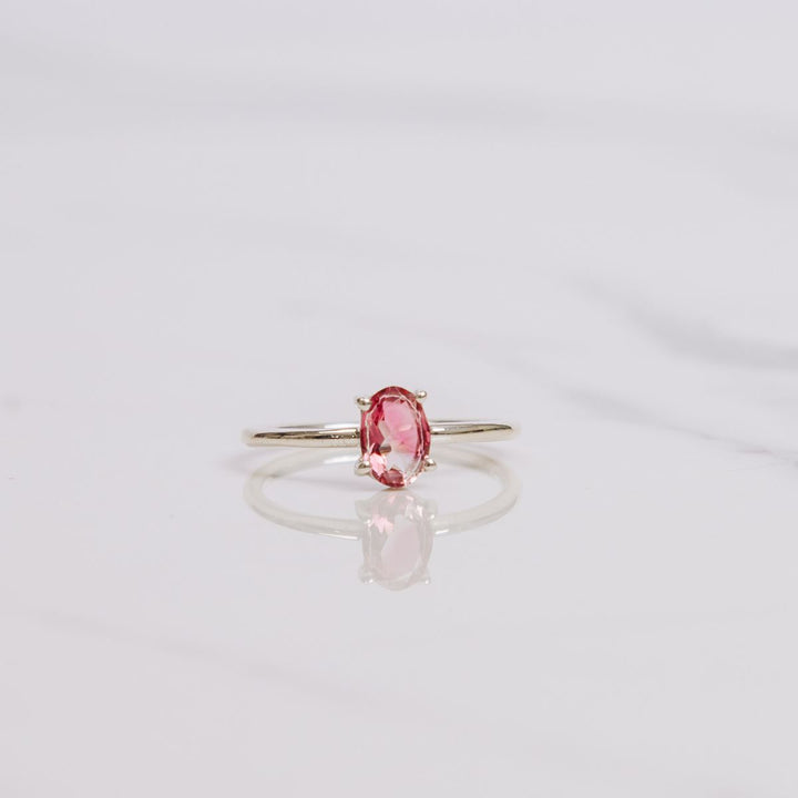 an oval shaped gemstone ring on a white background
