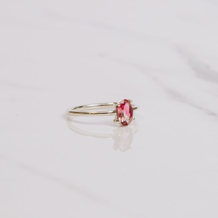 an oval shaped gemstone ring on a white background