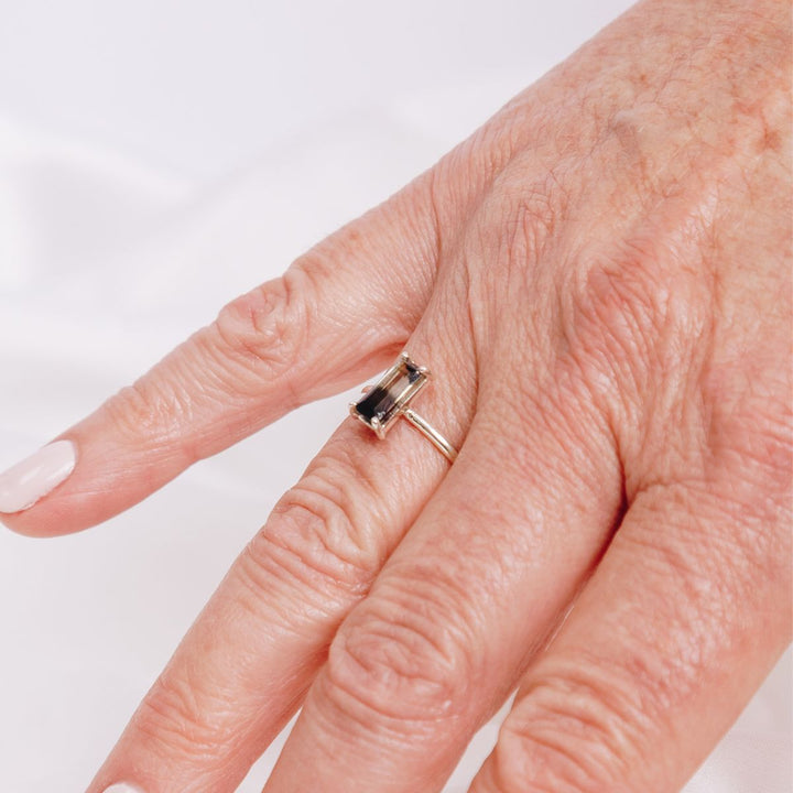 a woman wearing a very bold rectangular shaped ring on her finger