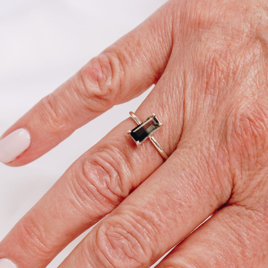 a woman wearing a very bold rectangular shaped ring on her finger 