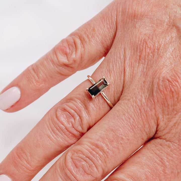 a woman wearing a very bold rectangular shaped ring on her finger