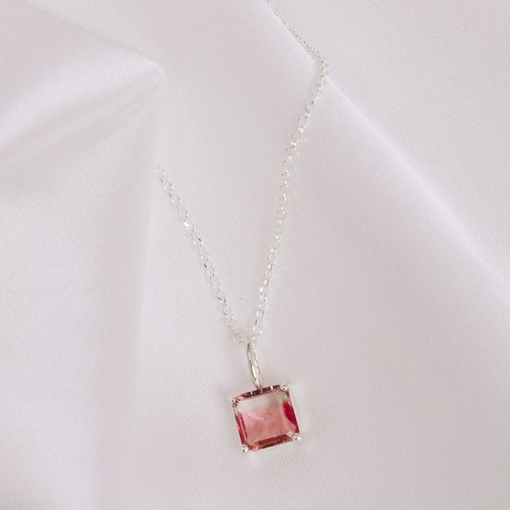 a pendant necklace on a white cloth