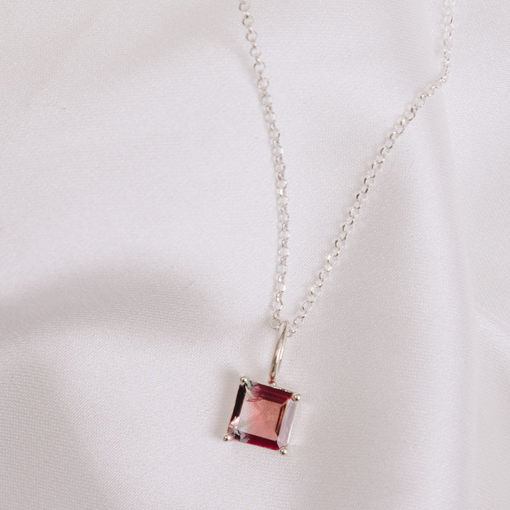 a pendant necklace on a white cloth