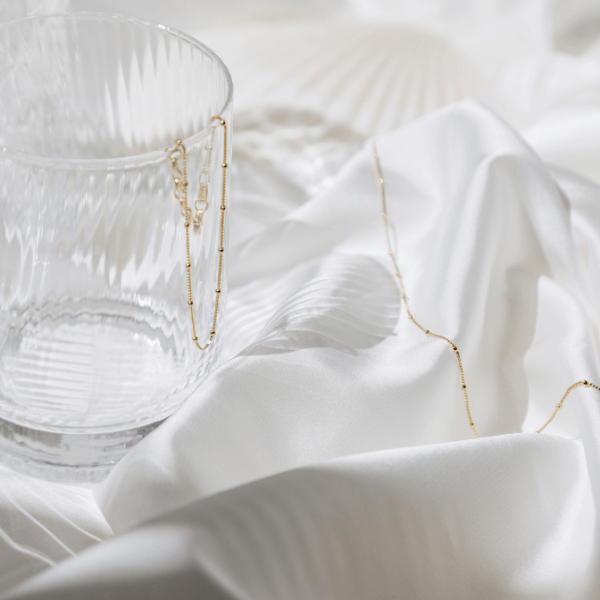 waterproof modern dotted bracelet hanging on glass and white sheet