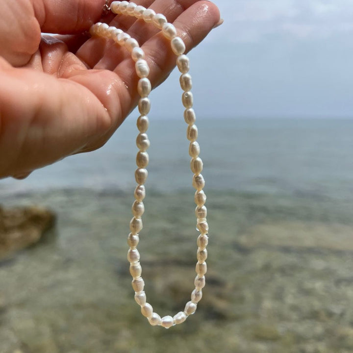female holding pearl necklace