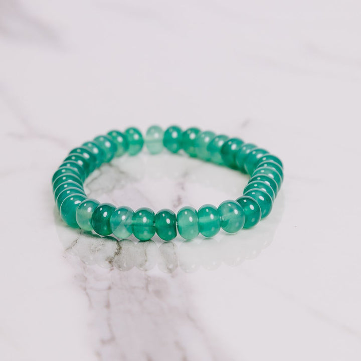 a green onyx button bracelet on a white cloth