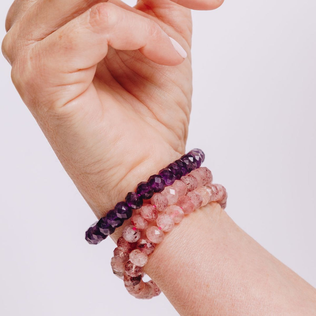 a woman wearing three facetted bracelets on her wrist 