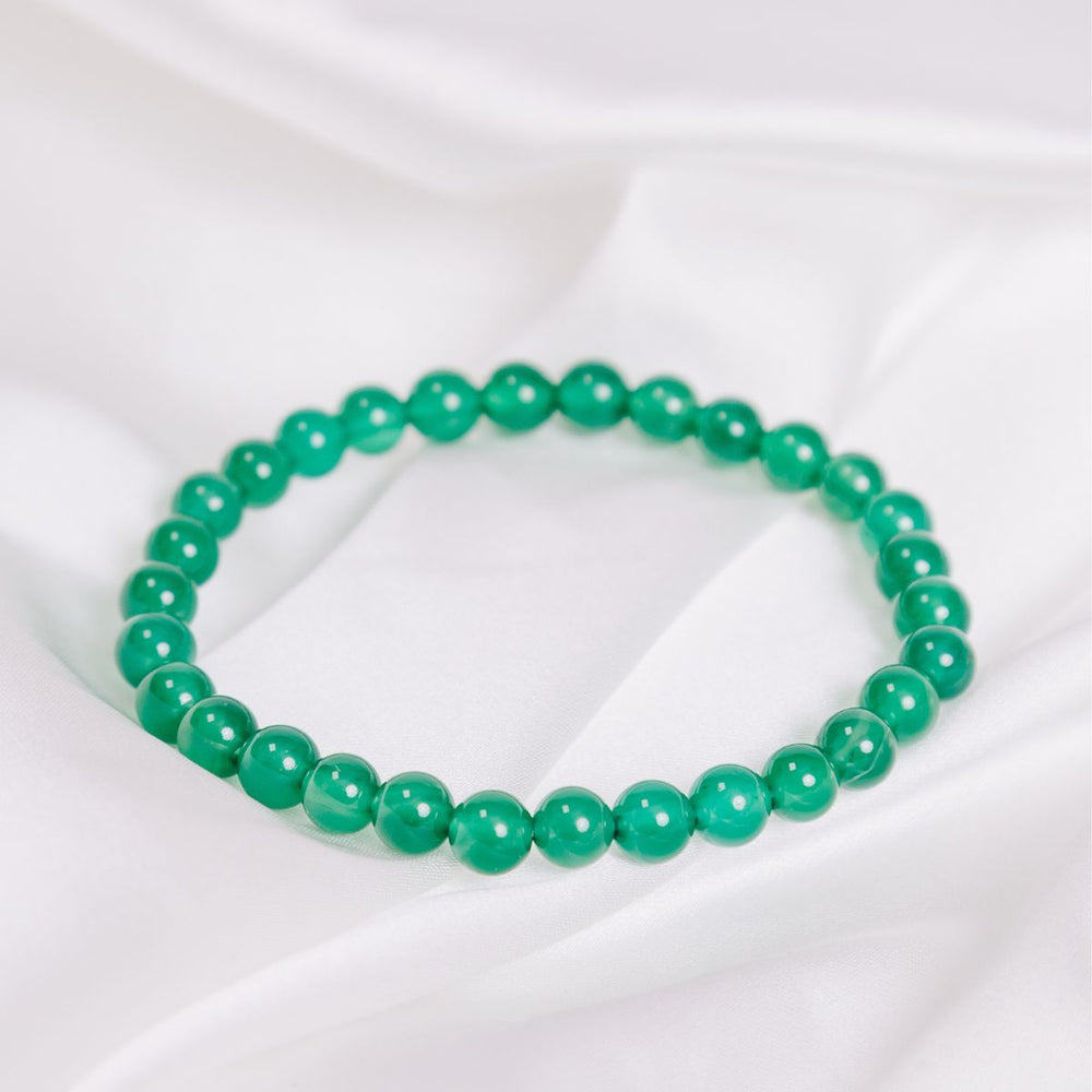 a green onyx bracelet on a white cloth