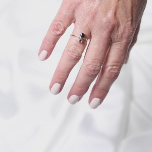 a woman wearing a very bold rectangular shaped ring on her finger