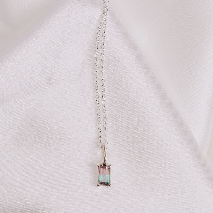 a pendant necklace on a white cloth