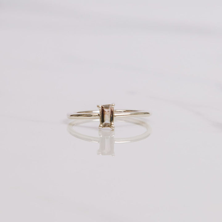 a gemstone ring on a white background