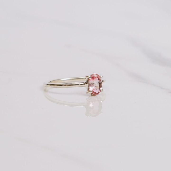 an oval shaped gemstone ring on a white background