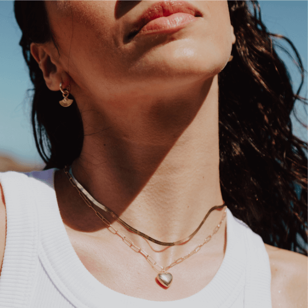 waterproof herringbone necklace layered on model 