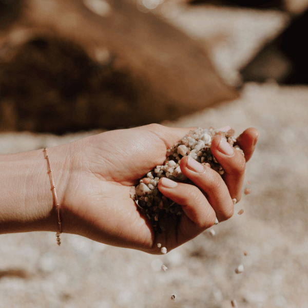 waterproof modern dotted bracelet on model hand holding sand