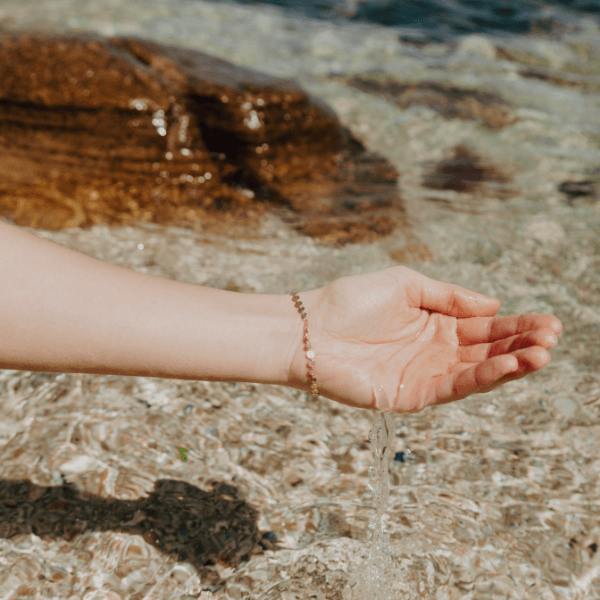 Waterproof Sequin Bracelet on model hand over water