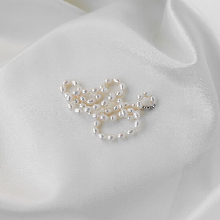 pearl necklace on white satin